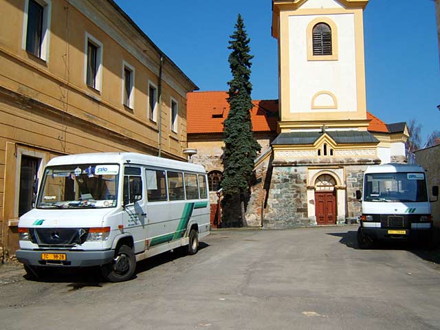 Pod bezdružickým kostelem na obrázku odpočívá vlevo  Mercedes Benz 814 D pro 20 sedících cestujících, vpravo je Mercedes Benz 614 D pro 
22 cestujících.